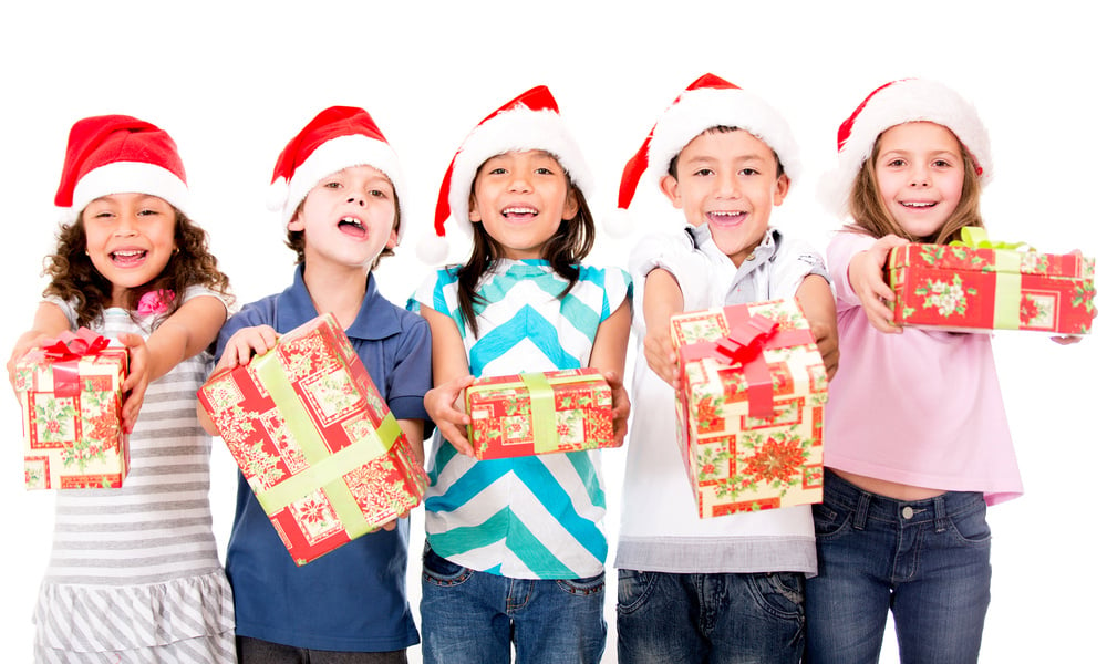 Group of kids holding Christmas presents - isolated over a white background