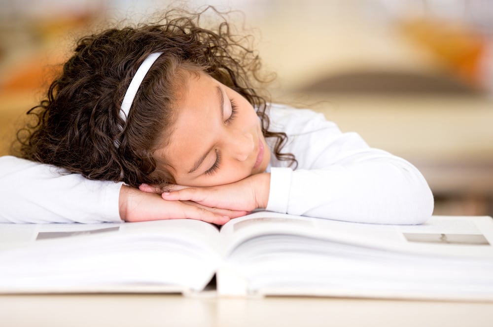 Tired girl falling asleep after reading a book