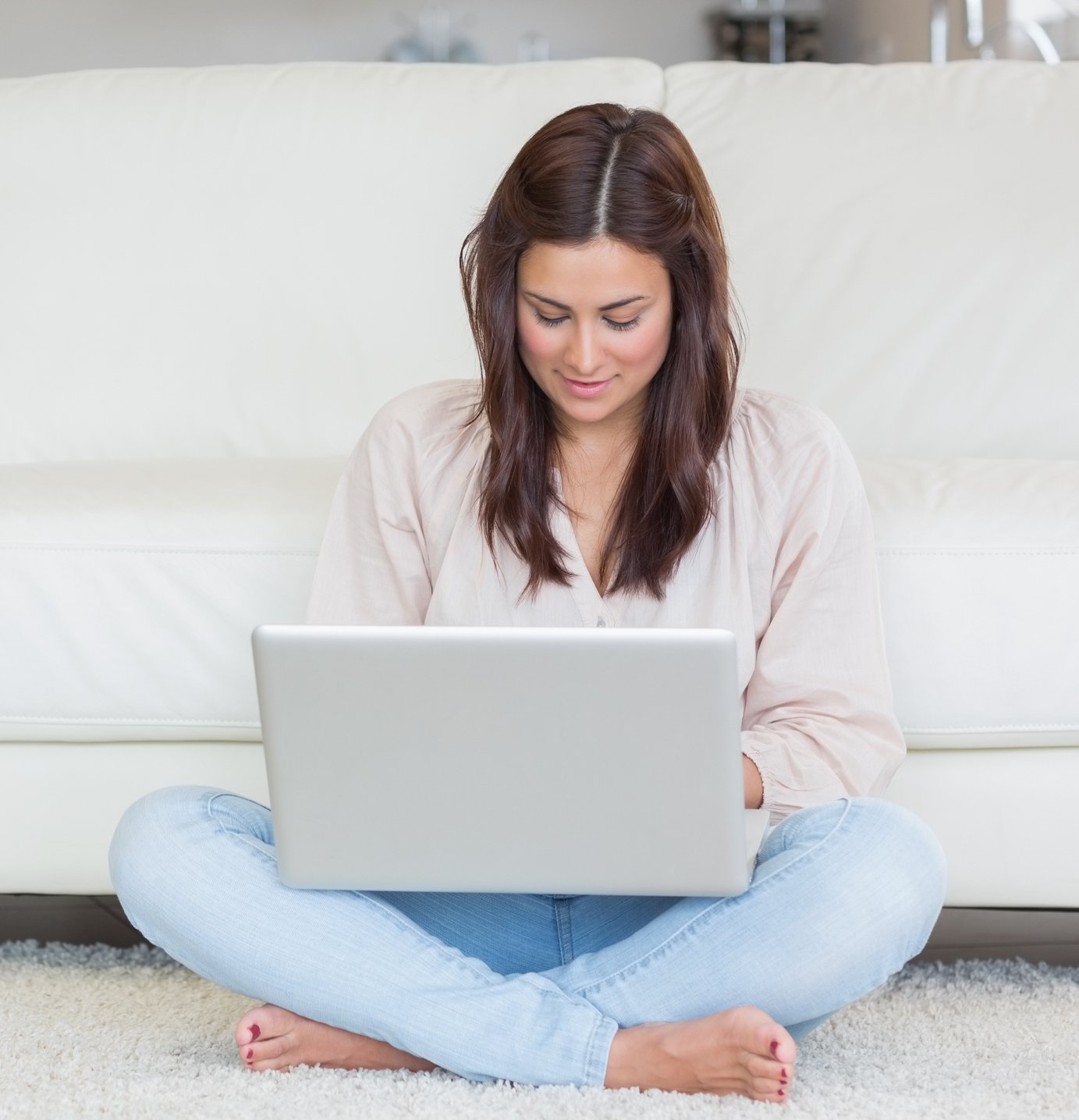 woman on laptop near couch