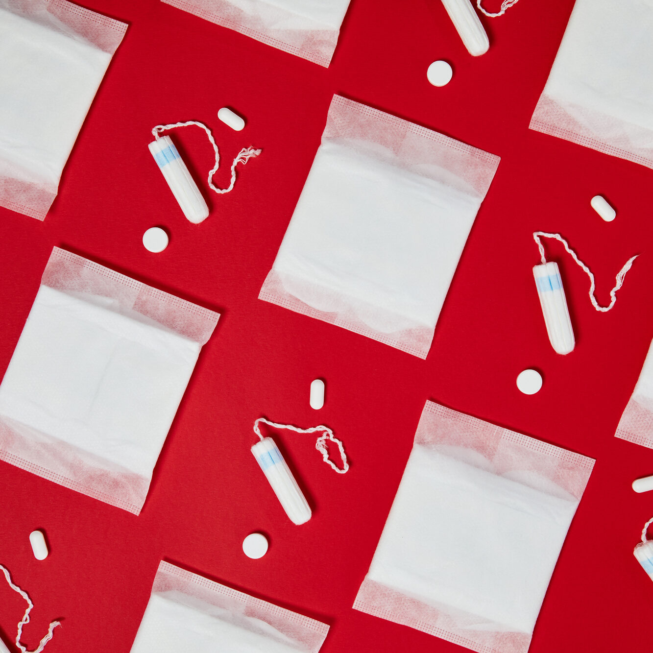 Pattern with white menstrual cotton pads and tampons isolated on red background. Feminine hygiene products